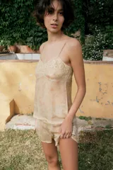 Top de tirantes finos confeccionado en organza semitransparente con estampado floral sutil. Presenta escote en pico con aplicaciones de bordados florales a contraste y terminación en puntilla en el bajo.