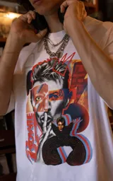 Remera blanca de manga corta y cuello redondo con calce oversize. Presenta un estampado frontal artístico y colorido de David Bowie.