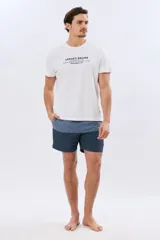 Short de baño con diseño de bloques de color en tonos celeste y azul marino, con cintura elástica en color verde claro y cordón ajustable.