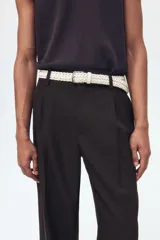 Pantalón sastrero de sarga en color marrón oscuro, con corte holgado, piernas amplias con raya marcada, cierre frontal con botón y corchete ocultos, bolsillos laterales al bies y bolsillos traseros insertados.