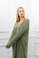 Vestido largo de tejido acanalado color verde oliva, con capucha, escote en V y mangas largas. Presenta bolsillos laterales y aberturas en los bajos.