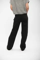 Pantalón de jean negro de corte wide leg, con tiro alto y cierre frontal con botón y cremallera.