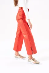 Pantalón wide leg color rojo metalizado, de tiro medio y corte ancho con aberturas laterales en el ruedo.