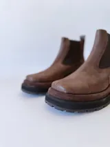 Bota Chelsea de cuero color marrón chocolate con elástico lateral negro y suela track color negro.