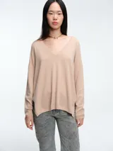 Sweater de escote en V profundo, confeccionado en tejido ligero con micro lentejuelas. Presenta hombros caídos, mangas largas y un calce relajado.