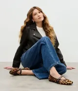 Zapatilla estilo Mary Jane de cuero con estampado animal print de leopardo. Presenta una tira superior ajustable con hebilla metálica dorada y detalles de ribete en color marrón oscuro.
