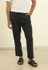 Pantalón de lino y algodón color azul marino, de corte relajado (relaxed fit) con cintura elástica ajustable mediante cordón. Presenta bolsillos frontales y bolsillos traseros.