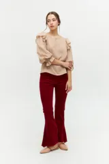 Blusa color rosa pálido de algodón con mangas cortas abullonadas y volados en el escote.