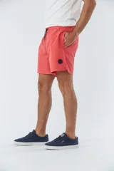 Short de baño liso con cintura elástica y cordón de ajuste. Cuenta con dos bolsillos laterales, un bolsillo posterior y un aplique de logo en goma en la pierna.