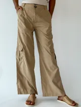 Pantalón cargo violeta de corte ancho, con bolsillos laterales y cintura con cinturón trenzado blanco.