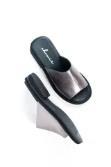 Sandalias chatas de cuero color peltre, fabricadas en Uruguay.