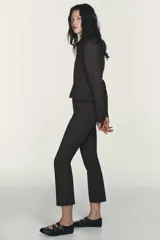 Cazadora entallada de color gris oscuro, con cuello solapa, manga larga y cierre frontal con cremallera de doble cursor. Presenta costuras marcadas y forro interior.