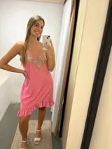 Vestido corto rosado con breteles finos, escote en V con aplique bordado dorado y volados en el ruedo.