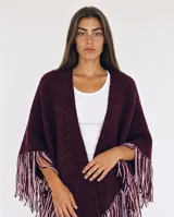Ruana de lana merino color borravino con flecos bicolor en tonos bordó y rosado.