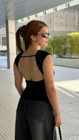 Remera blanca de algodón, de corte ajustado y diseño sin mangas con hombros ligeramente estructurados.
