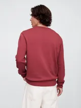 Buzo deportivo Gap color crudo, de corte recto, con cuello redondo y logo Gap NYC estampado en verde.