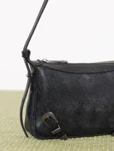 Mini cartera bandolera de cuero vacuno flor color negro con interior al tono. La correa regulable combina cuero y pelo, y lleva hebillas metálicas personalizadas.