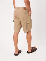Bermuda cargo de gabardina color beige, con bolsillos laterales con fuelle en las piernas, bolsillos delanteros tipo ojal y traseros. Cuenta con presillas para cinto y cierre frontal con botón y cierre.