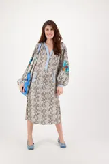 Vestido largo de manga larga con tapeta y largo medio con aberturas laterales, con estampado de serpiente y detalles florales en las mangas.