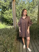 Vestido camisero blanco de lino italiano, con cuello camisero, cierre frontal con botones, mangas cortas con doble volado y bolsillos laterales.