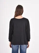 Remera de manga larga color negro, con cuello redondo y puños elásticos, de corte holgado.