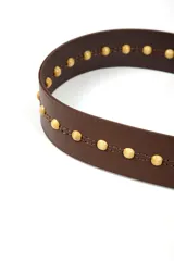 Cinturón marrón con cuentas doradas y cierre con cordones.