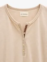 Remera de manga larga By Florencia, confeccionada en algodón con spandex, de calce ajustado. Presenta escote redondo con cartera frontal abotonada y detalle de cordón en contratono.