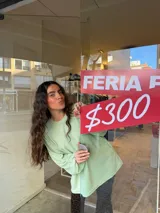 Buzo verde menta de punto con cuello redondo, mangas largas holgadas y puños fruncidos.