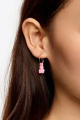 Aros de aro pequeño en color dorado con un dije colgante en forma de conejo de color blanco con acabado flocado.