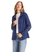 Campera liviana de modal color azul, con cierre frontal mediante broches metálicos, cuello con solapa y mangas largas con apliques de bordado floral calado.