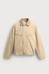 Cazadora relaxed fit de denim de algodón en color beige, con cuello de solapa en piel combinada a tono, manga larga con puño abotonado, bolsillos con cierre de cremallera en el pecho y cierre frontal con cremallera oculta por solapa con botones.