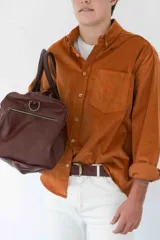 Camisa de pana azul marino de manga larga con cuello abotonado, cierre frontal con botones color hueso, bolsillo de parche en el pecho izquierdo y logo bordado en el bolsillo.