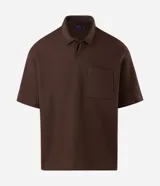 Remera polo de manga corta y corte regular, confeccionada en tejido texturizado color marrón, con cuello camisero, cartera corta con botones y un bolsillo aplicado en el pecho.