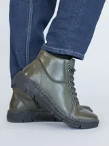 Botines de cuero color verde oliva con cordones negros, suela de poliuretano negra y diseño de caña baja.