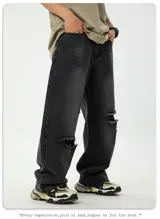 Jean de corte ancho y holgado, color negro lavado con efecto desgastado y roturas visibles en la parte delantera de las piernas. Presenta cinco bolsillos.