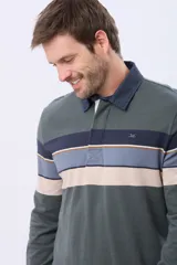 Remera polo de manga larga con cuello azul oscuro y solapa blanca. Presenta un diseño de rayas horizontales en tonos azul oscuro, marrón, verde grisáceo y celeste. Incluye un logo bordado en el pecho.