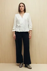 Pantalón wide leg color crudo, de tiro alto, con grandes bolsillos laterales y traseros.