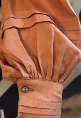 Blusa color crudo confeccionada en lino de alto gramaje, con cartera frontal con puntilla y caída natural.