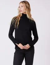 Polera de tejido fino, color rosado, con cuello alto, manga larga y detalle de tajo en los puños.