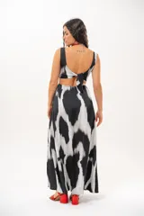 Vestido largo de satén con estampado abstracto en blanco y negro, escote en V, aberturas cut-out en la cintura y aberturas laterales en la falda.
