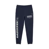 Pantalón de jogging azul marino de corte slim fit con cintura elástica y cordón ajustable. Estampado con el logo de Lacoste en blanco en la pierna izquierda.