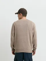 Sweater de punto color ladrillo con cuello en V y mangas largas.