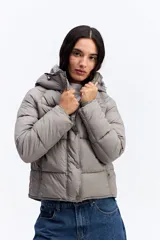 Campera puffer negra con capucha, diseño corto y acolchado, cierre frontal con botones a presión y puños ajustados.