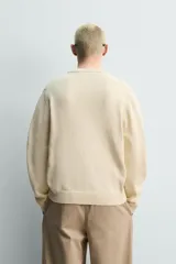 Cardigan de punto en hilatura de algodón y lino, con ajuste regular, cuello redondo, manga larga y acabados en rib. Presenta cierre frontal de botonadura con botones oscuros.