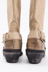 Bota de cuero marrón con caña alta y estribo desmontable.