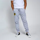 Pantalón de jogging gris melange, corte ajustado con puños elásticos en los tobillos y cordón negro en la cintura. Presenta un escudo bordado del Club Atlético Peñarol en amarillo y negro en el muslo izquierdo.