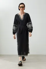 Túnica larga color crudo con bordados rojos en cuello, mangas y ruedo.