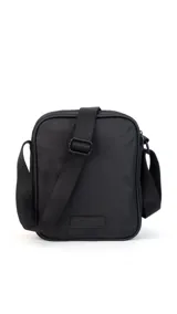 Morral de tela impermeable color negro, de forma rectangular y diseño compacto. Cuenta con correa ajustable para llevar al hombro o cruzado, y múltiples compartimentos con cierre, incluyendo un bolsillo frontal vertical con cierre.