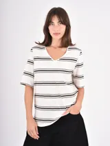 Remera de cuello en V con estampado de rayas horizontales en tonos negro, beige y blanco, de manga corta y corte recto.