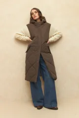 Chaleco largo marrón capitoneado con capucha, cierre frontal y bolsillos laterales. Forro interno de satén con estampado animal print.